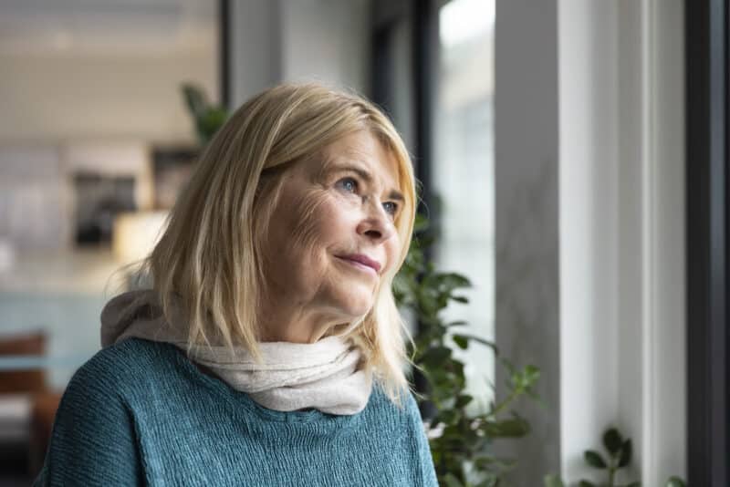 Godt voksen dame ser tankefullt uv vinduet